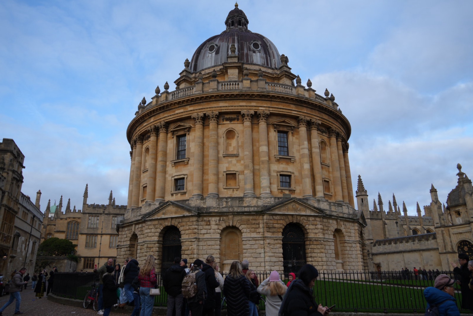 The Radcliffe Camera in Oxford, sandstone rotunda with crowd at the base